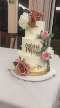 Cargar y reproducir el video en el visor de la galería, Video del pastel de despedida de soltera de tres pisos con betún de mantequilla. Decoración con flores y un topper de “bride to be
