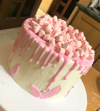 Cargar imagen en el visor de la galería, Pastel de vainilla cubierto de betún de mantequilla color rosa con bombones rosas y plumas de chocolate blanco. 
